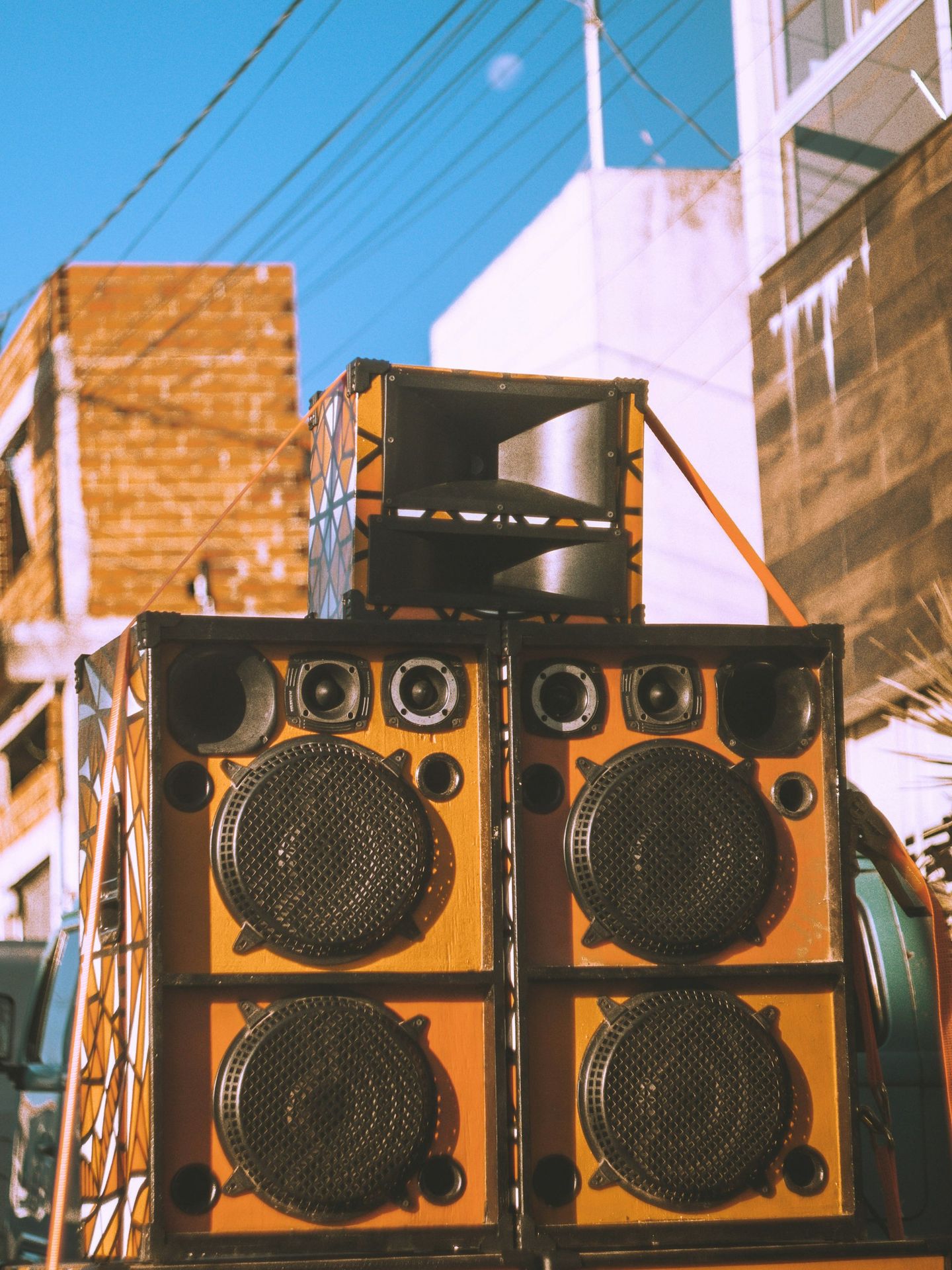 Giant speakers are stacked outside on a city street.